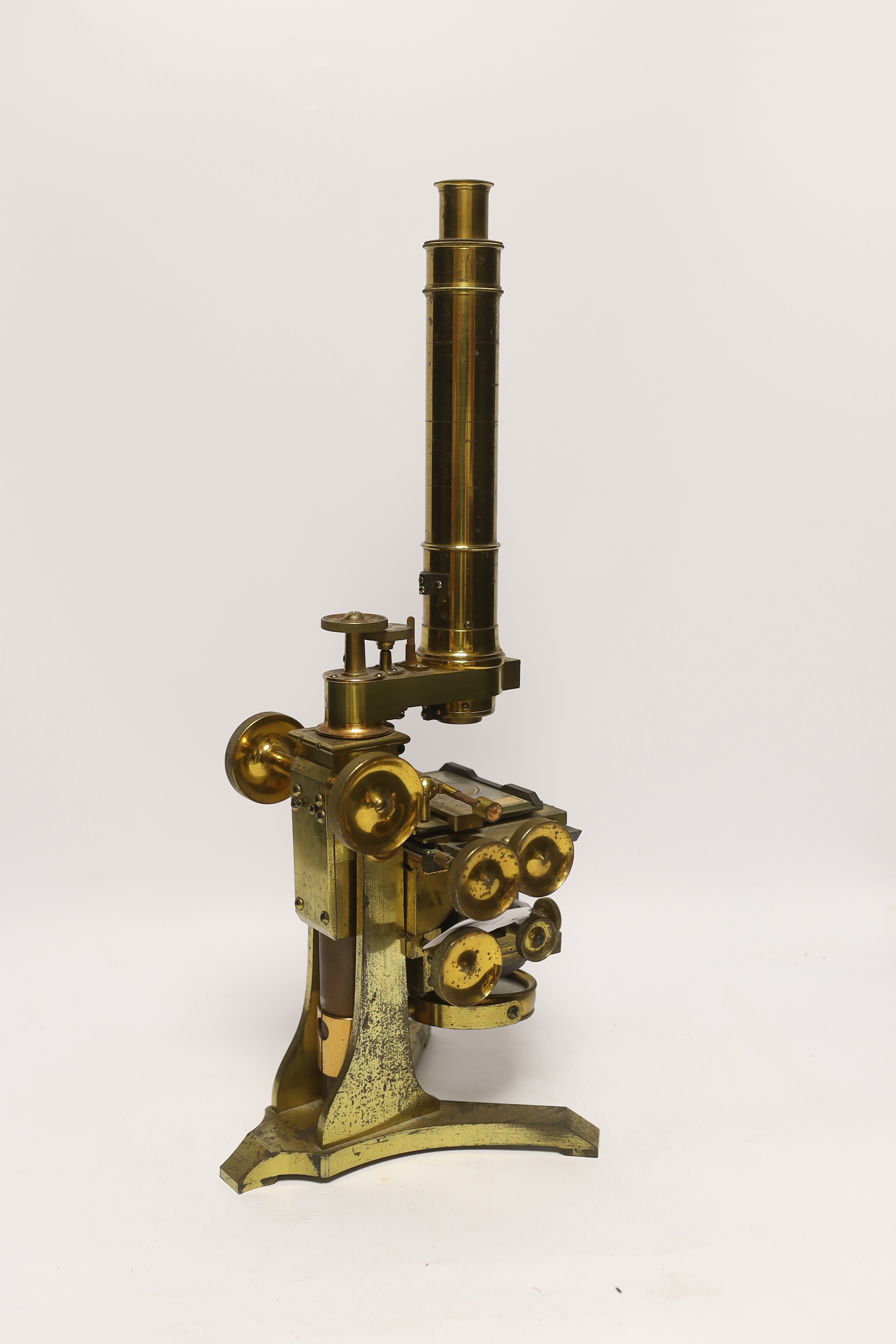 A brass microscope with mahogany box by A. Ross of London, dated 1890 to foot, with some unusual features including a rotating box under the bed for lens, box with fitted interior containing additional lens and other att
